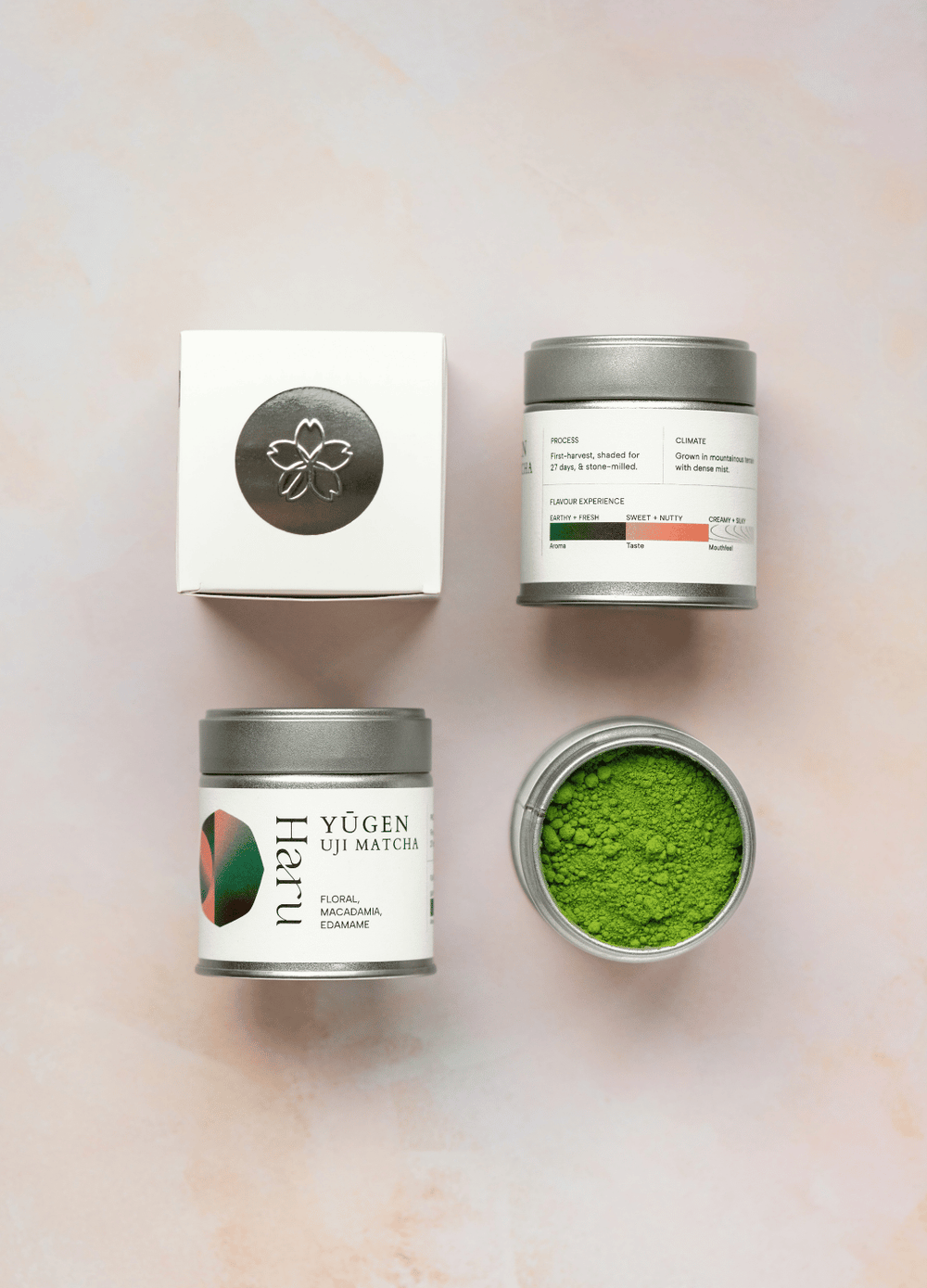 A 30g box of Haru Uji Matcha Yugen (Floral Macadamia, Edamame) on a light pink marble background. The packaging is white with black text and a central circular graphic showing pink, green, and dark green segments.