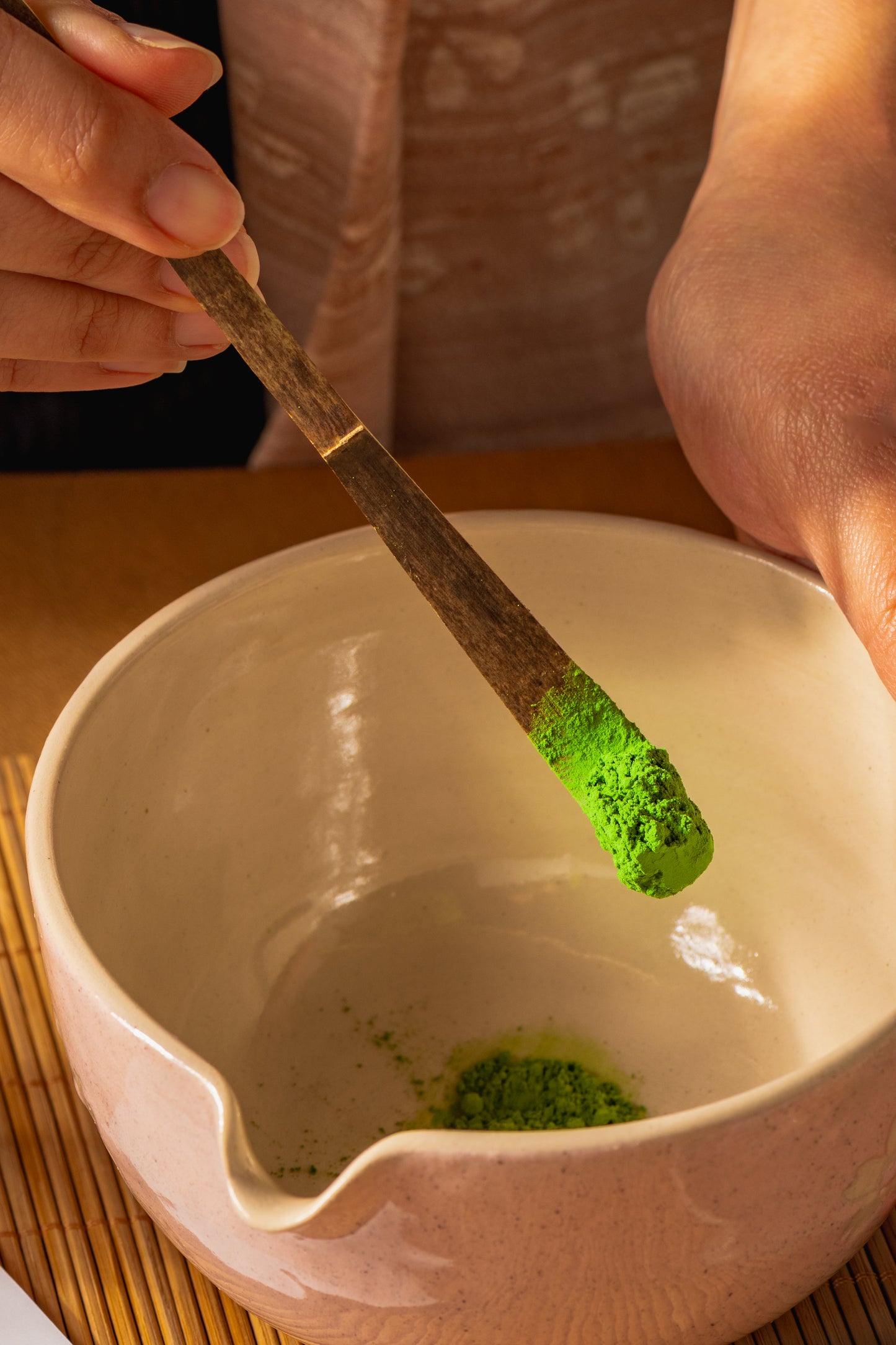 Person holding matcha powder on Chashaku