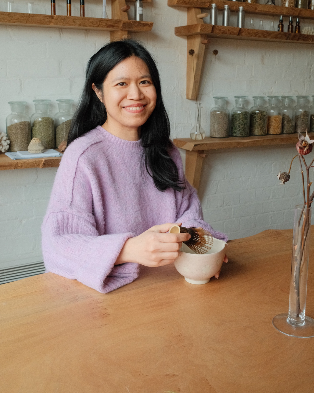 Nicha the co-founder holding a matcha whisk
